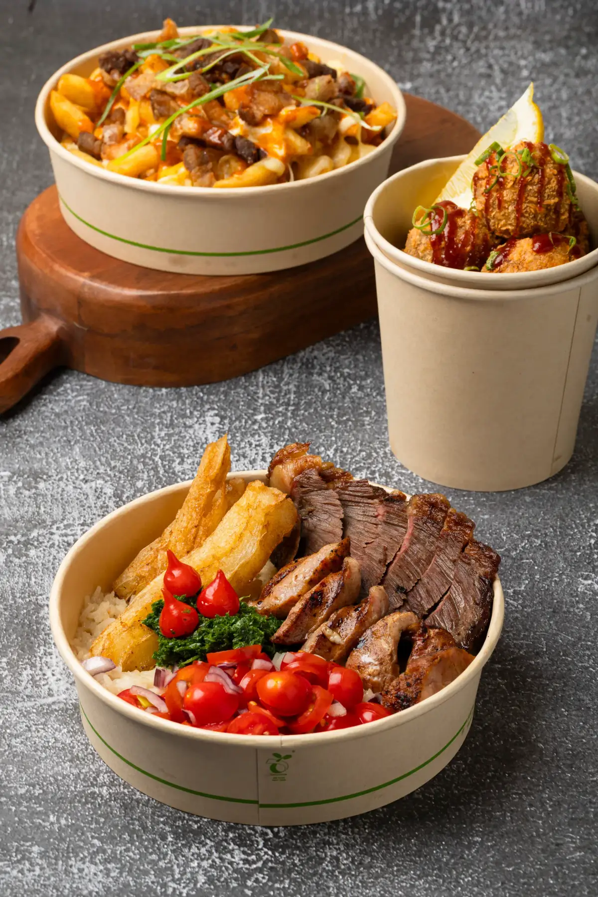 Uai Mate Brazilian street food lineup featuring loaded fries, croquete cup, and BBQ carreteiro bowl on grey background