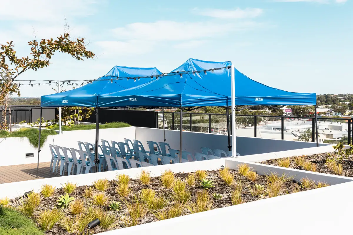 Blue event marquees and rows of white chairs set up on a rooftop terrace for a Vera Living event in Cannington