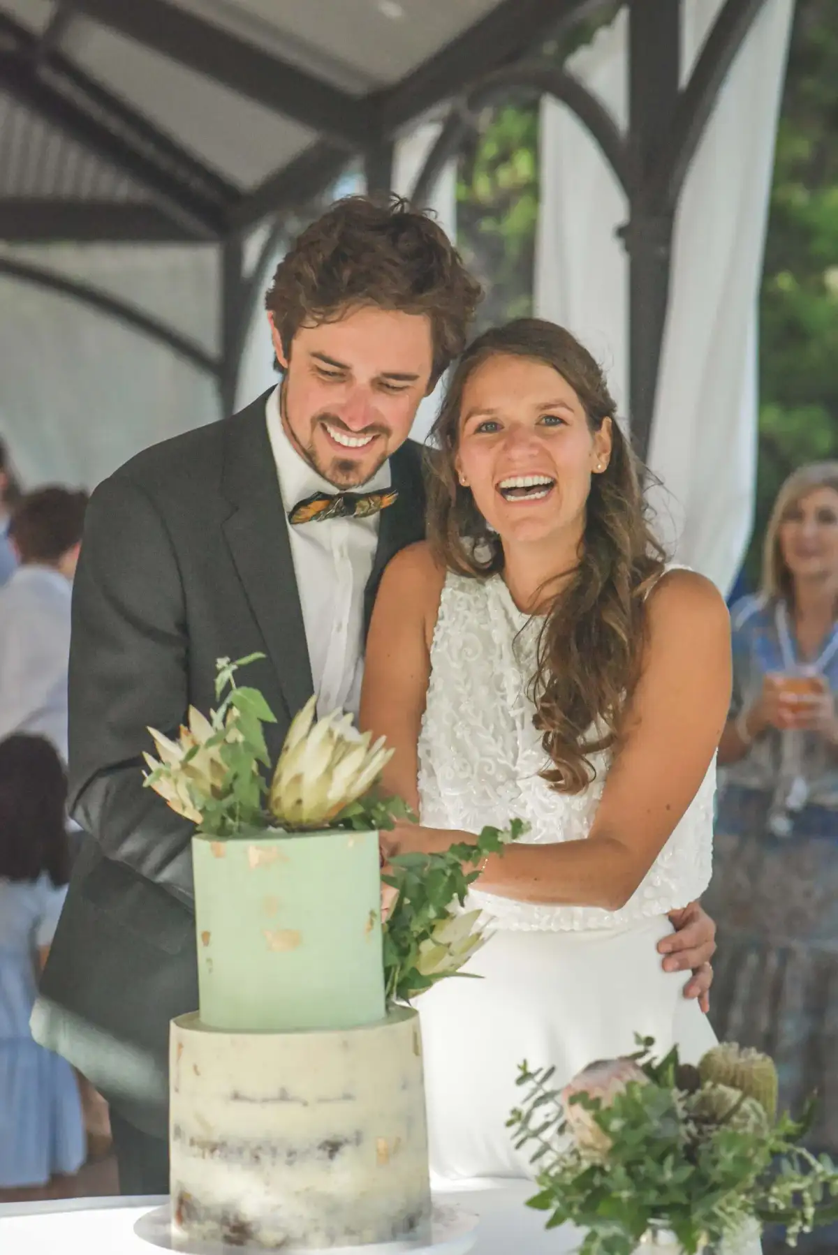 Newlyweds cutting their wedding cake during an intimate reception.