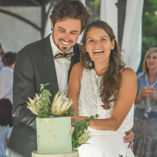 Newlyweds cutting their wedding cake at an intimate celebration.
