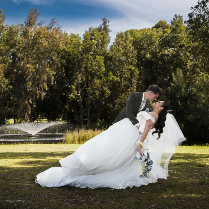 Wedding couple dip kiss portrait beside the water during a Perth wedding shoot.
