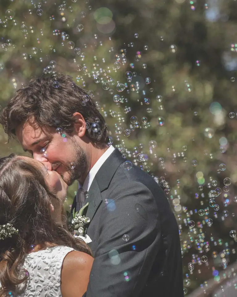 Wedding couple kissing as bubbles float around them during a Perth celebration.