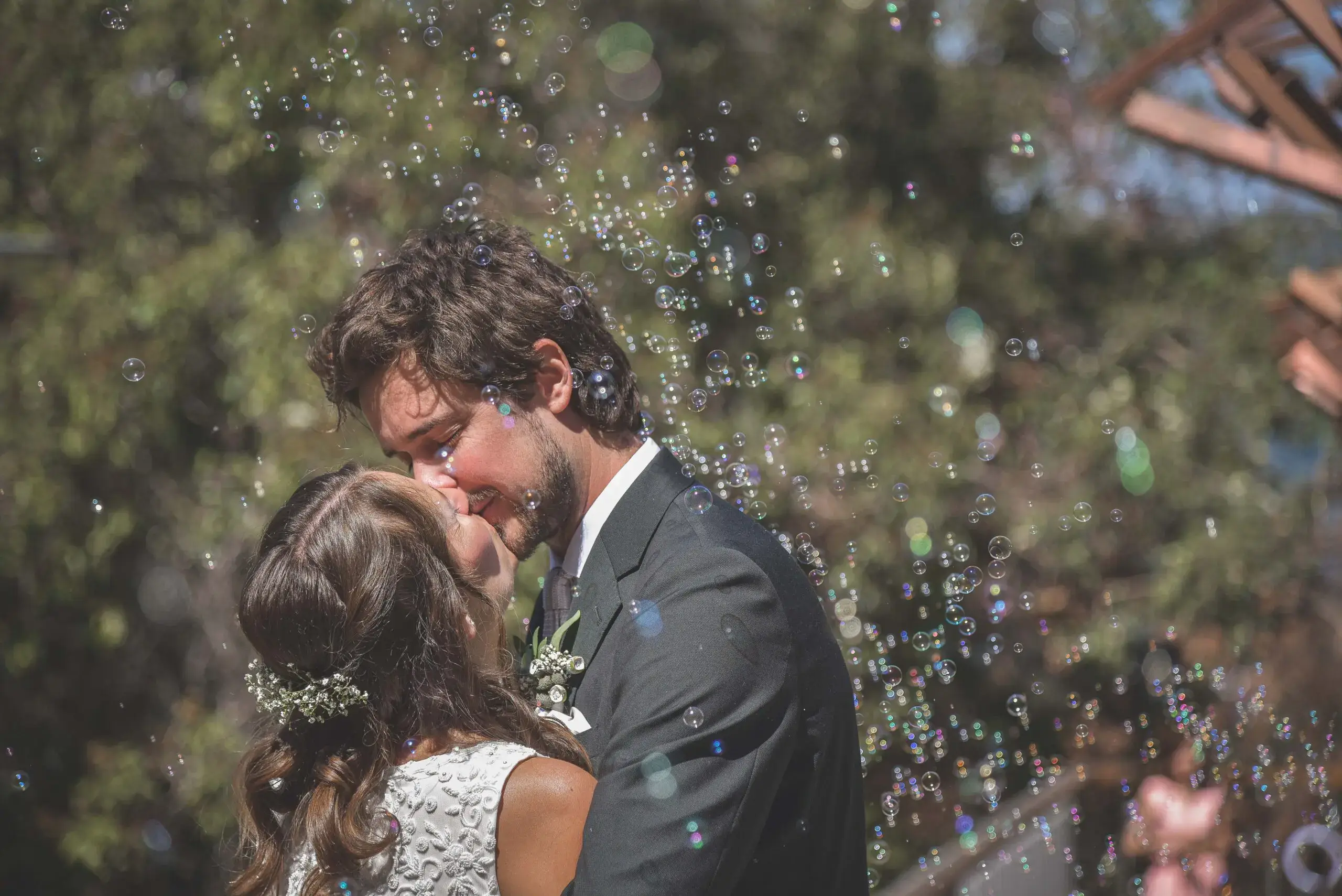 Bride and groom kissing with bubbles during a Perth wedding celebration