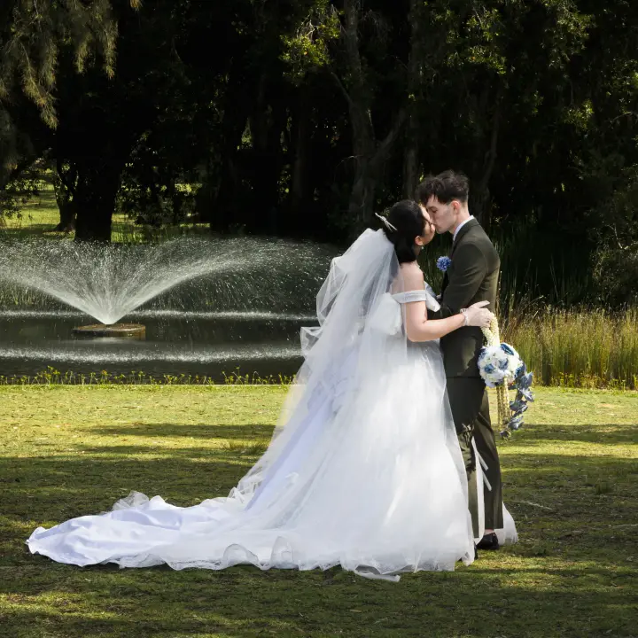 Wedding couple kissing by a fountain during an outdoor Perth portrait session.
