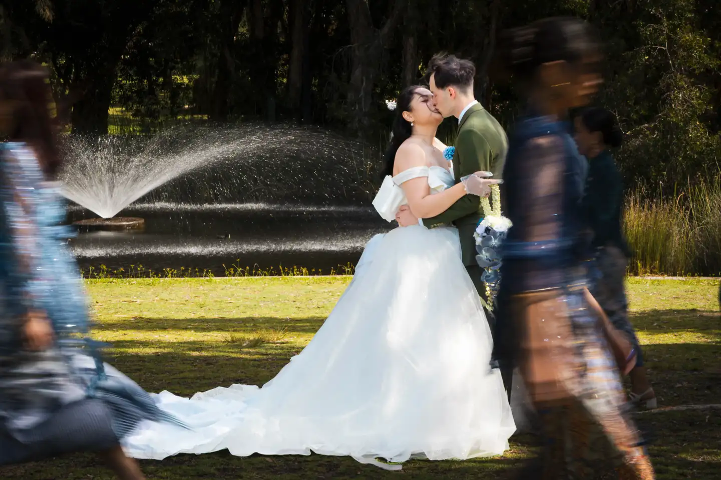 Wedding couple kissing while guests celebrate around them.
