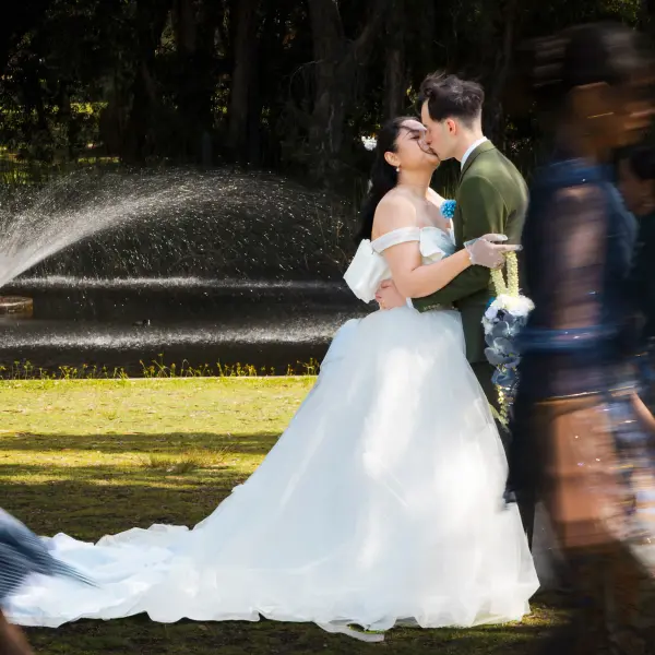Wedding couple kissing as guests celebrate around them.