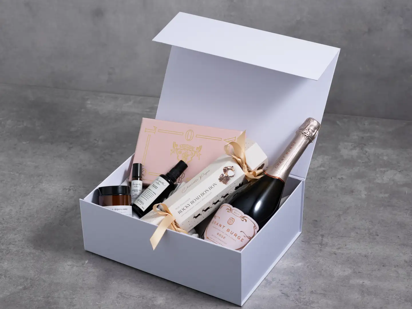 White skincare gift hamper styled with rose details for a beauty launch.